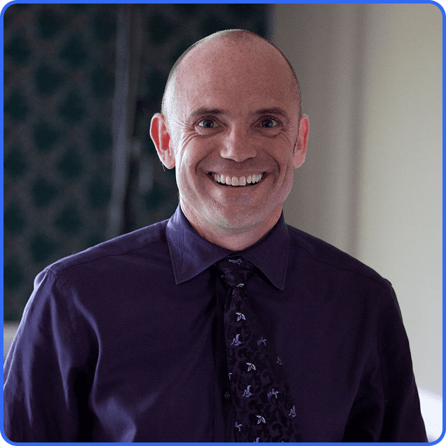 Smiling person wearing a purple shirt.